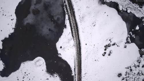 Aerial View of Snowy Road and Frozen Lake