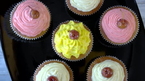 Colorful Frosted Cupcakes with Cherries on Tray