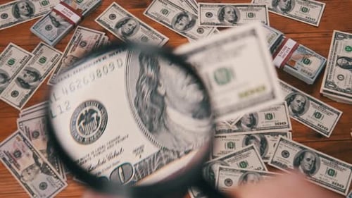 Inspecting One Hundred Dollar Bills with Magnifying Glass