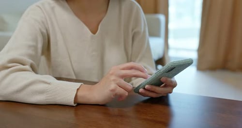 Frau benutzt Handy zu Hause
