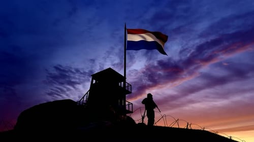 Soldier Guarding Border with Waving Flag at Sunset