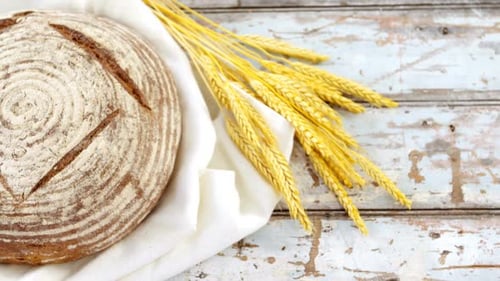Artisan Bread with Wheat on Rustic Wooden Surface