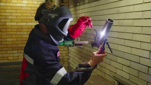 Metal Welder Working with Arc Welding Machine to Weld Steel at Factory While Wearing Safety