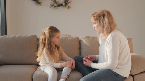 Girl and Woman Talking on Sofa Indoors