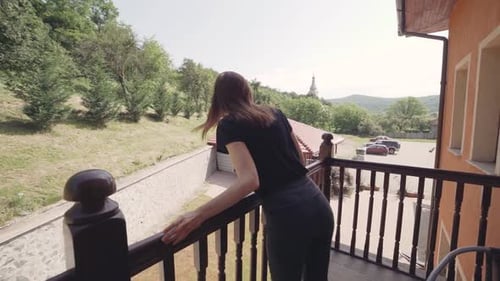 Belle jeune femme se relaxant sur le balcon