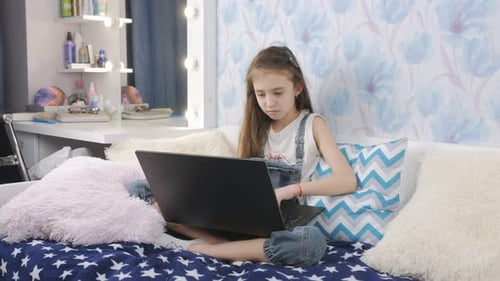 Girl Using Laptop While Sitting on Bed