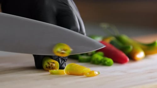 Close Up of Peppers Being Sliced on Board