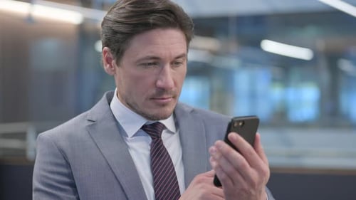 Man in Suit Using Mobile Phone in Office
