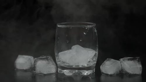 Whiskey with Ice. Pouring Whisky Rum From the Bottle on Black Background