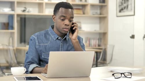 Afroamerikanische Designerin telefoniert über Arbeit