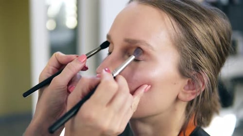Makeup Artist Applying Eye Shadow on Woman's Face