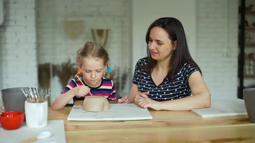 Little Girl Sculpts From Clay in Pottery Workshop