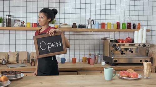 Woman Holding Open Sign in Coffee Shop