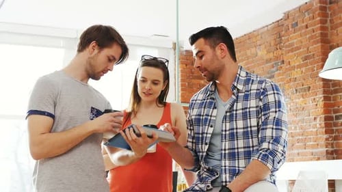 Teamwork in Modern Office Analyzing Tablet Together
