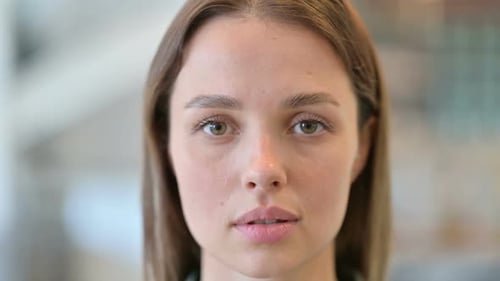 Nahaufnahme des Gesichts einer ernsten jungen Frau, die in die Kamera schaut