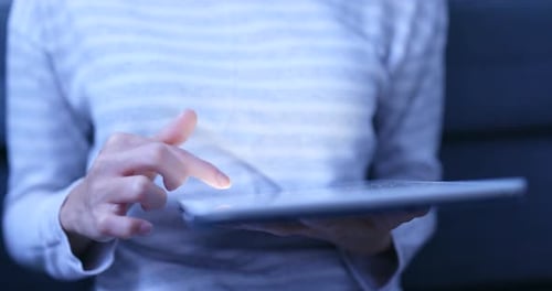 Woman use of tablet computer at night