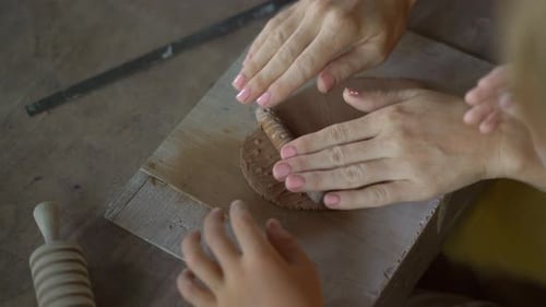 Child and Adult Working Together with Clay