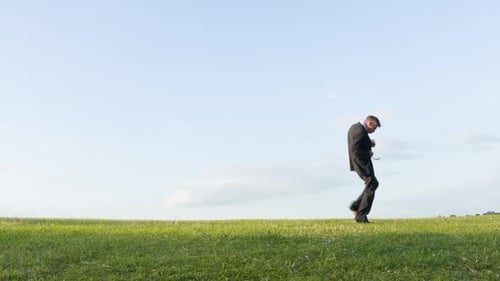 Man Playing Air Guitar on Green Field