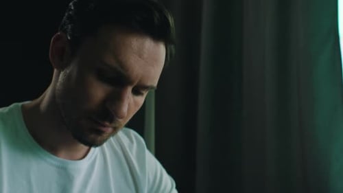 Man Writing in Notebook at Table