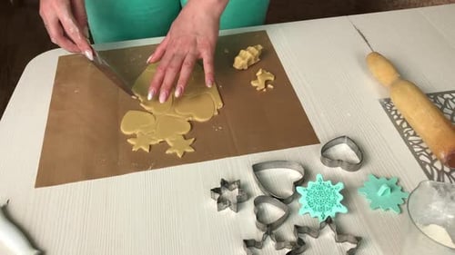 A Woman Works With A Snowflake And Heart Shaped Cookie Dough.