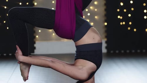 Woman Practices Aerial Yoga In Headstand Position