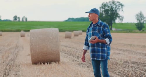 Farmer Using Digital Tablet While Examining Field