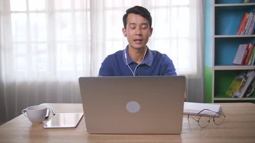 Young Adult Using Laptop for Video Conference at Home