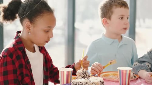 Group of Children Eating at Birthday Party in Funny Decorations