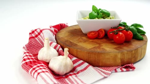 Cherry tomatoes and garlic with bowl of pasta