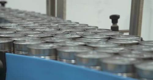 Metal Cans Moving on Conveyor Belt in Factory