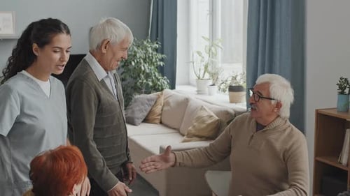 Personas mayores saludan a un recién llegado en un hogar