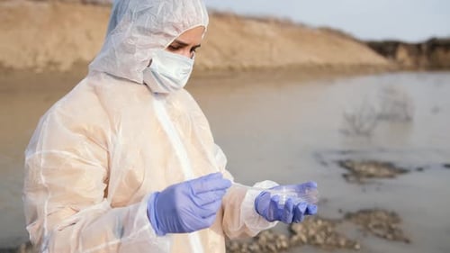 Scientist Collecting Water Sample in Protective Suit