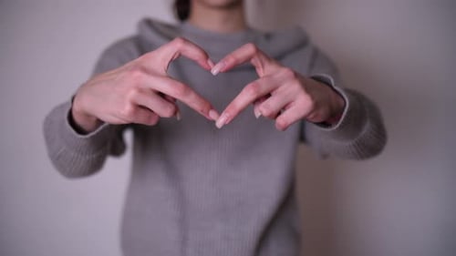 Person Forms Heart Shape With Hands
