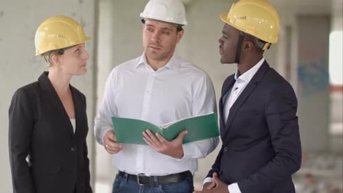 Gruppe lächelnder Baumeister in Hardhats mit Zwischenablage und Blaupause im Freien