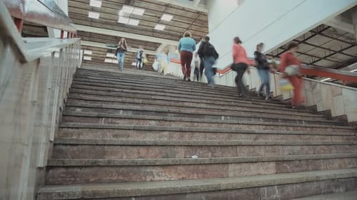 Time lapse of people in a busy metro station boarding trains and riding escalators