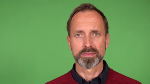 A Middleaged Handsome Caucasian Man Looks Seriously at the Camera Closeup Green Screen