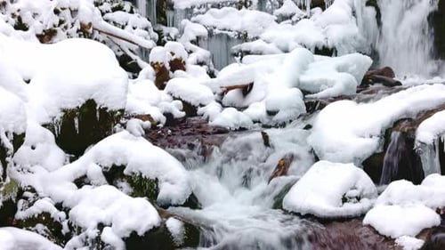 Winter Waterfall Cascading Down Snow Covered Rocks