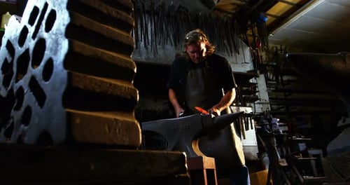 Blacksmith Shaping Hot Metal on Anvil