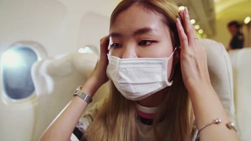 Traveler Wearing Face Mask While Traveling on Commercial Airplane