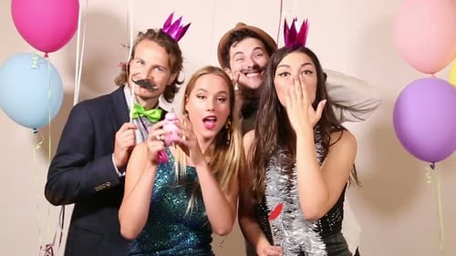 Group of happy friends in party photo booth
