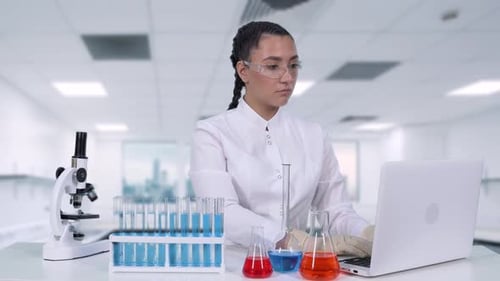 Young Woman Scientist Working in Lab with Laptop