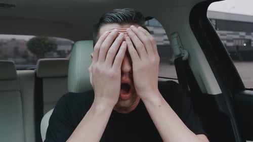 Portrait of Scared Young Man While Sitting in a Car in the Driver's Seat. Frightened Male Driver