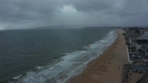 Sobrevolando una playa nublada y tormentosa en Bournemouth, Inglaterra