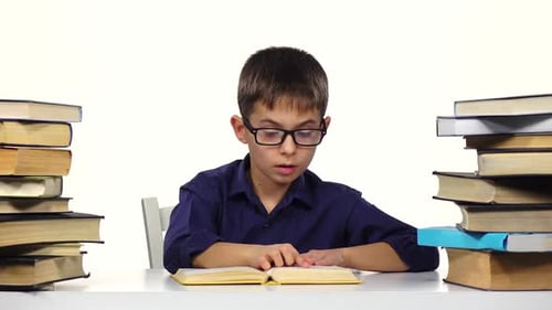 Boy Reading Book at Desk with Books