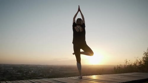 Woman Stand on Yoga Mat and Practicing Yoga Stretching Exercise Outdoors in Sunset