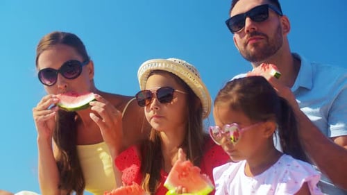 Family Enjoys Watermelon Together on Sunny Day