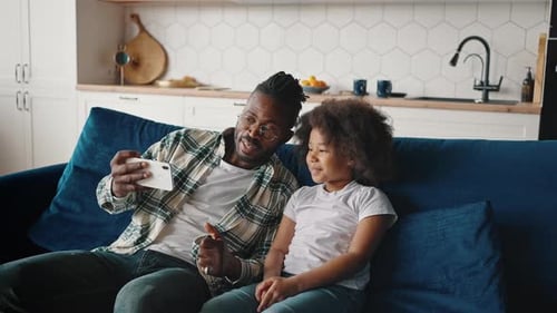Father and Daughter Taking a Selfie at Home