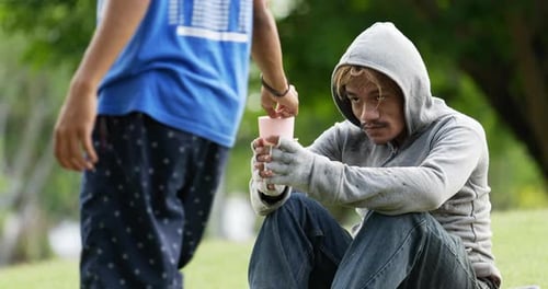 Child Gives Money to Adult in the Park
