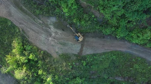 Above view of an excavator that is working on the road while zooming out