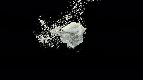 Des gouttes de lait entrent en collision pour former des éclaboussures sur fond noir